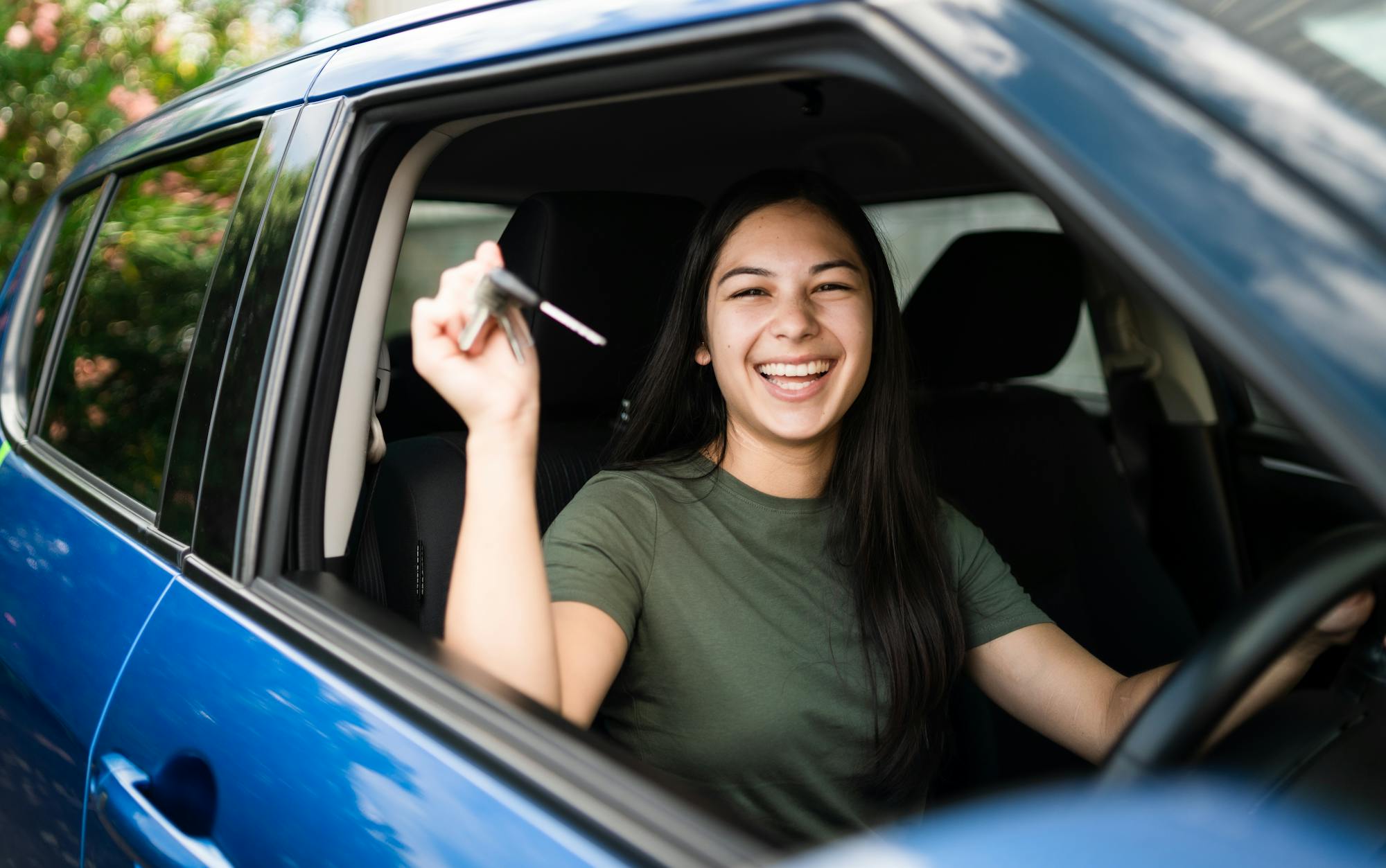 car insurance, woman with keys in hand proud of getting the licence to drive